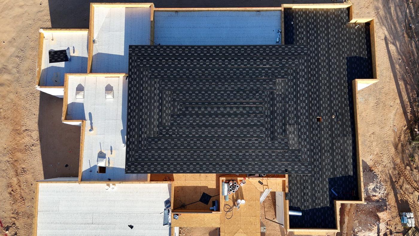Flat roof installation in progress on a custom home.