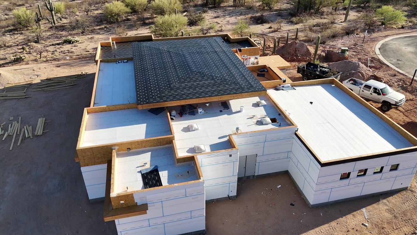 Flat roof installation in progress on a custom home.
