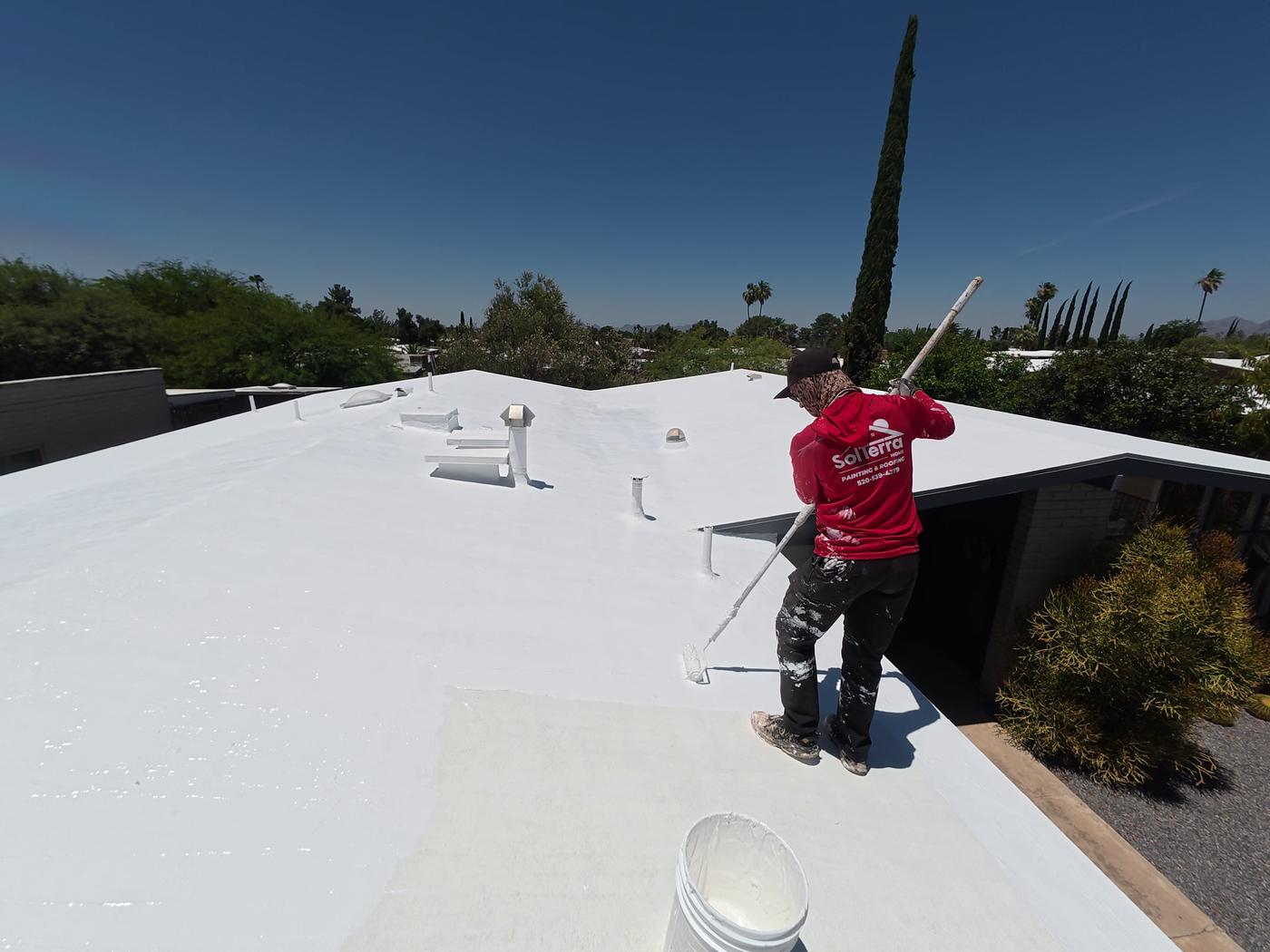 Flat roof coating application in progress.