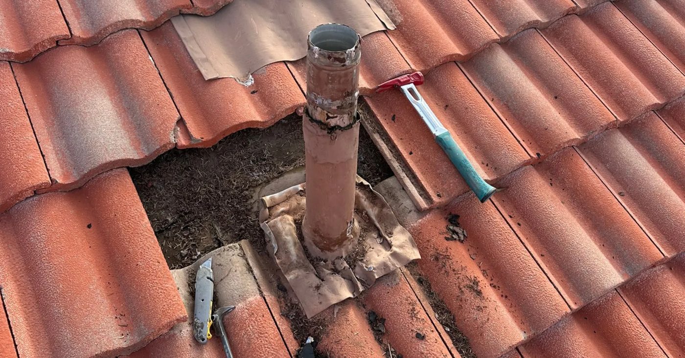 Deteriorated flashing around a roof vent pipe with the surrounding tile removed