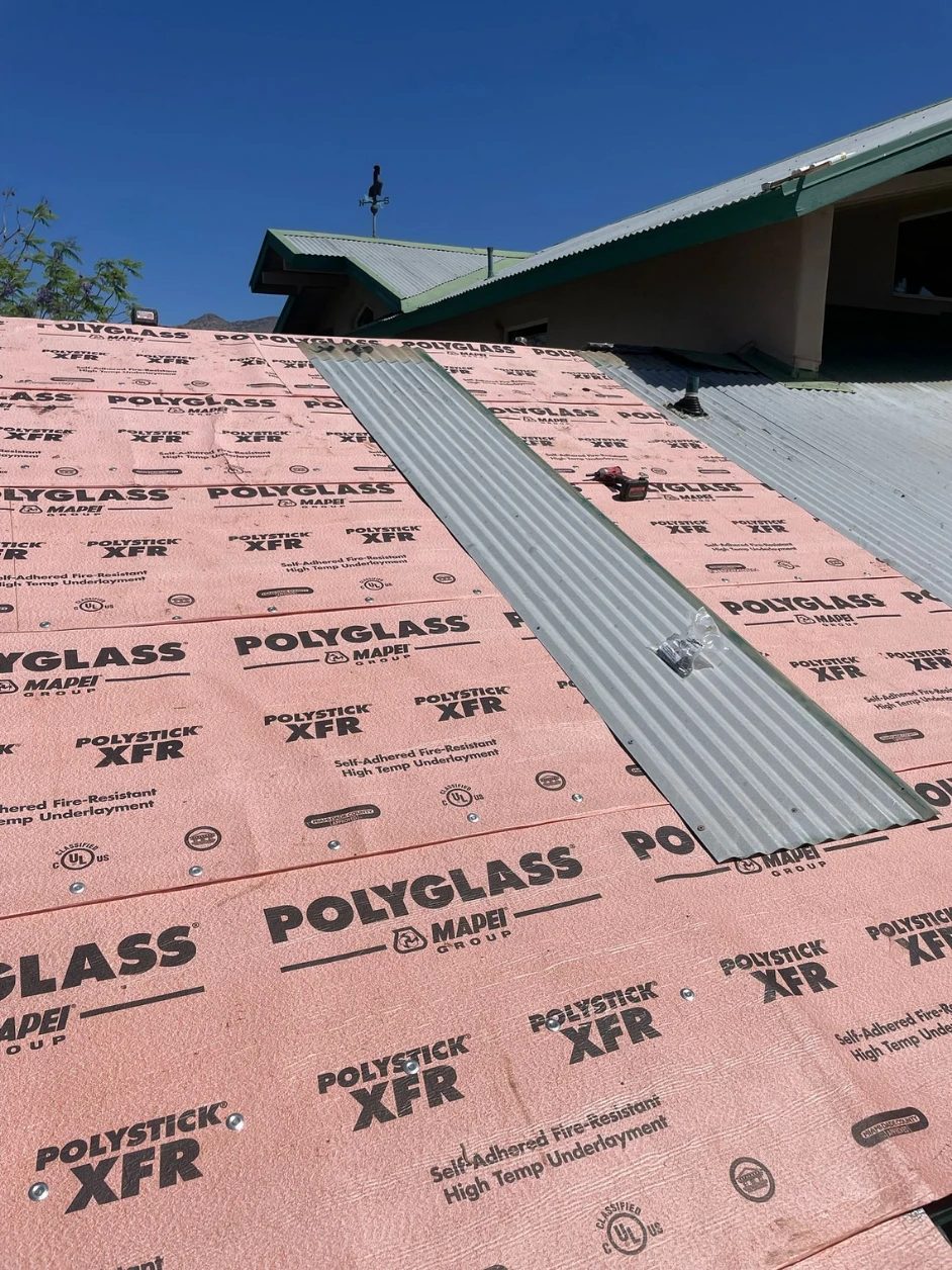 Polyglass fire-resistant underlayment installed with the first metal panel set in place