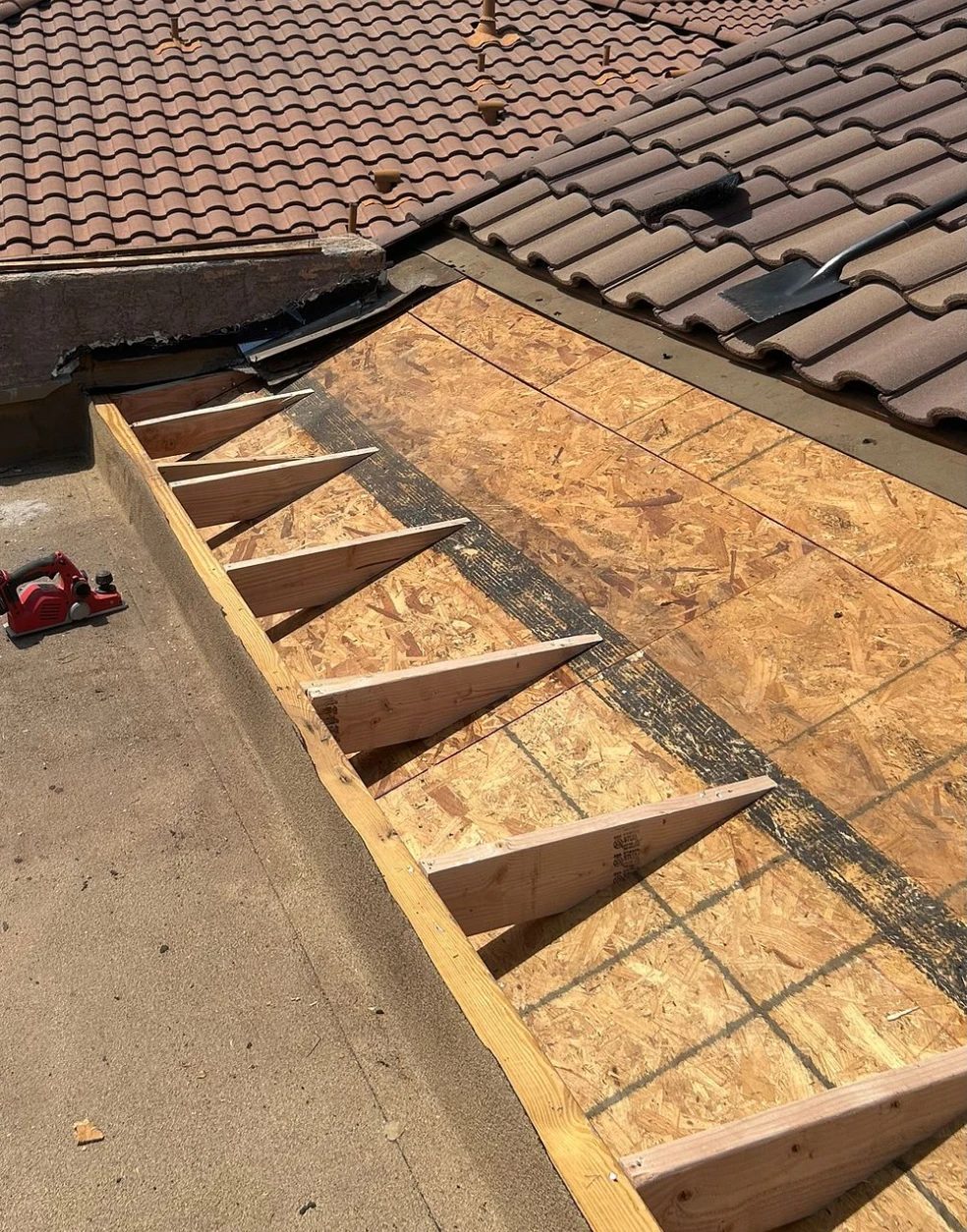Tapered framing built over new decking where the tile roof meets the flat roof