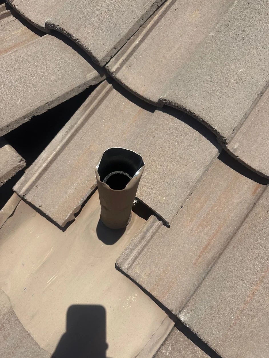 Plumbing stack on a Tucson tile roof with the tile cut away and its old flashing failing