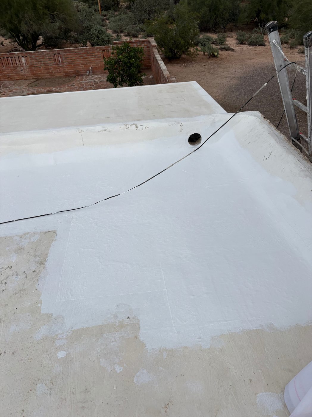 The corrected low area after coating, with water draining toward the outlet