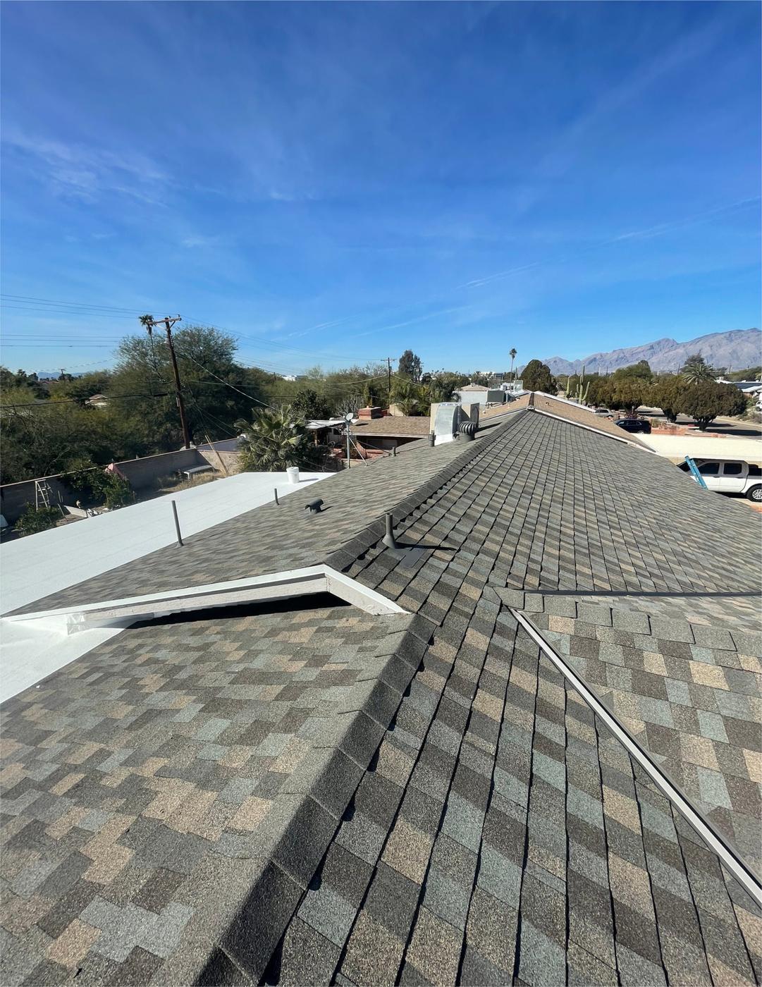 Finished Cedar Falls shingle roof showing valley flashing, roof-to-wall flashing, and a low-slope transition.