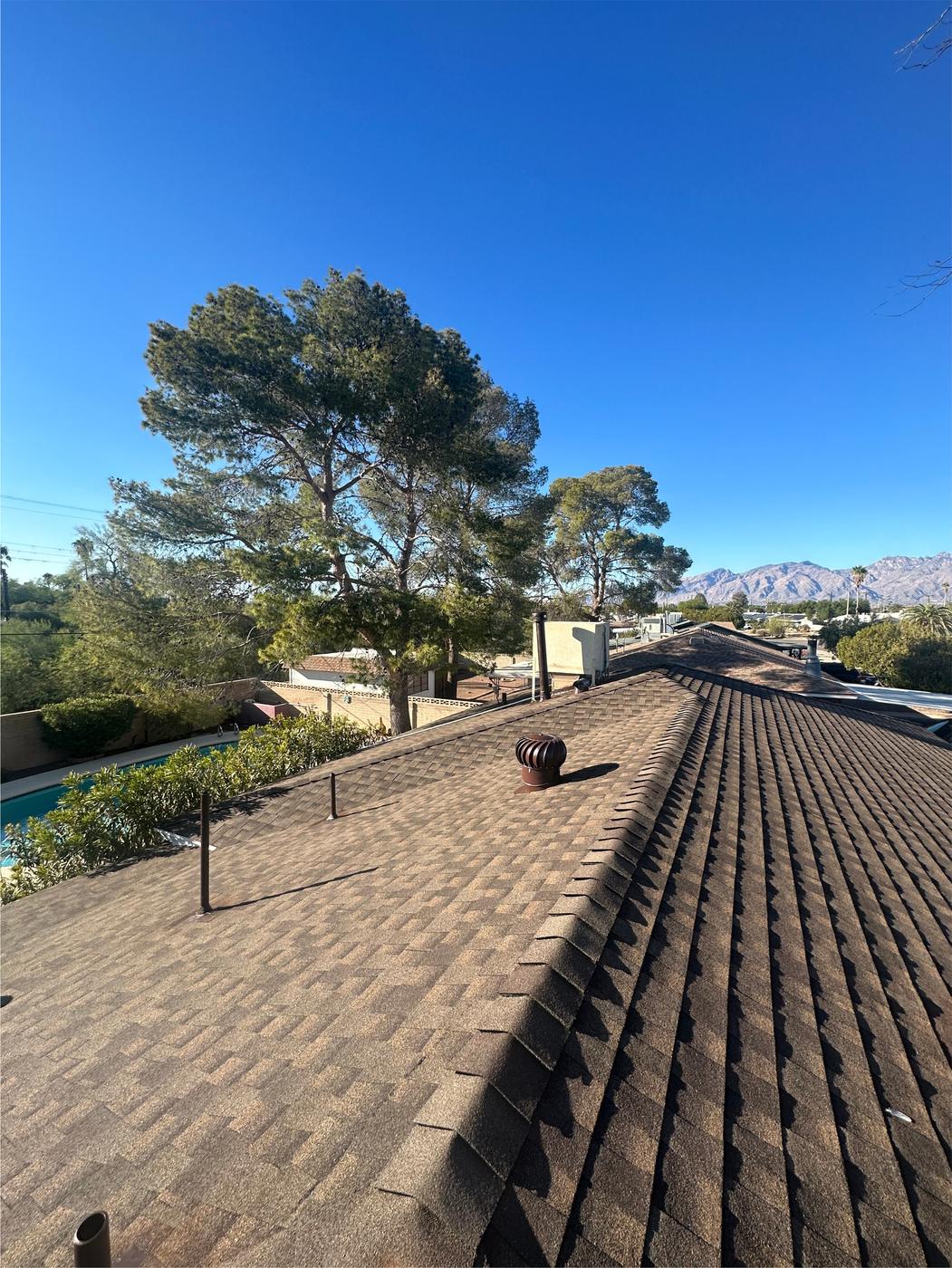 Finished GAF Barkwood shingle roof with matching ridge caps.