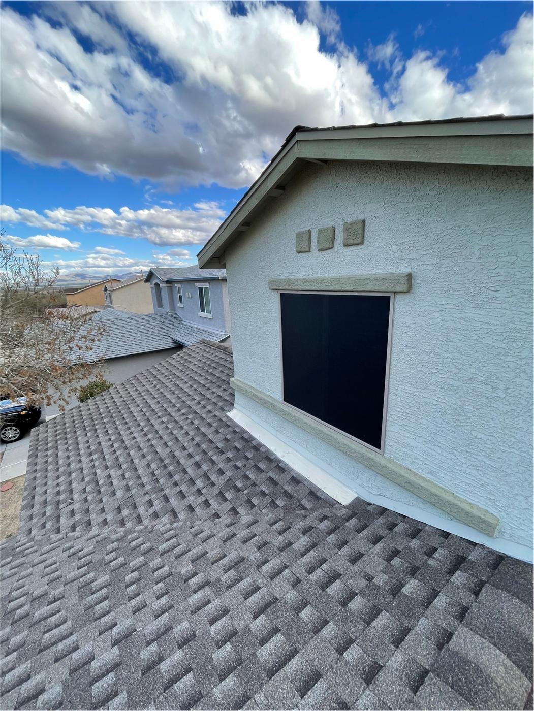 Finished shingle roof showing headwall flashing and a roof valley.