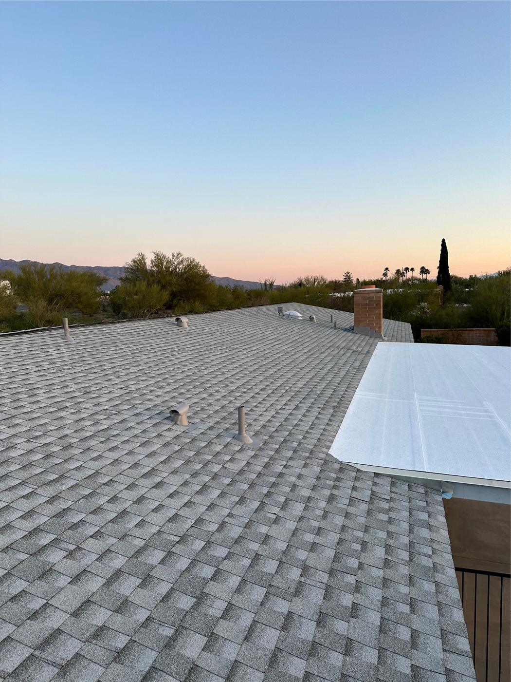 Finished Pewter Gray shingle roof with a low-slope transition and chimney flashing.