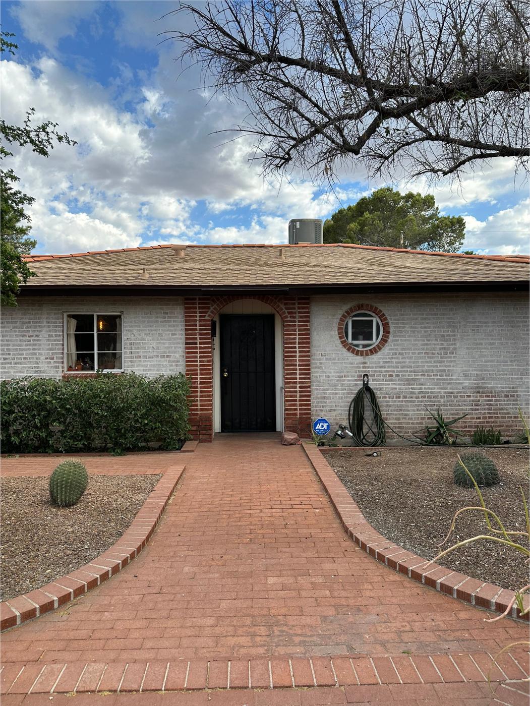 Finished asphalt shingle roof with clay tile ridge caps.
