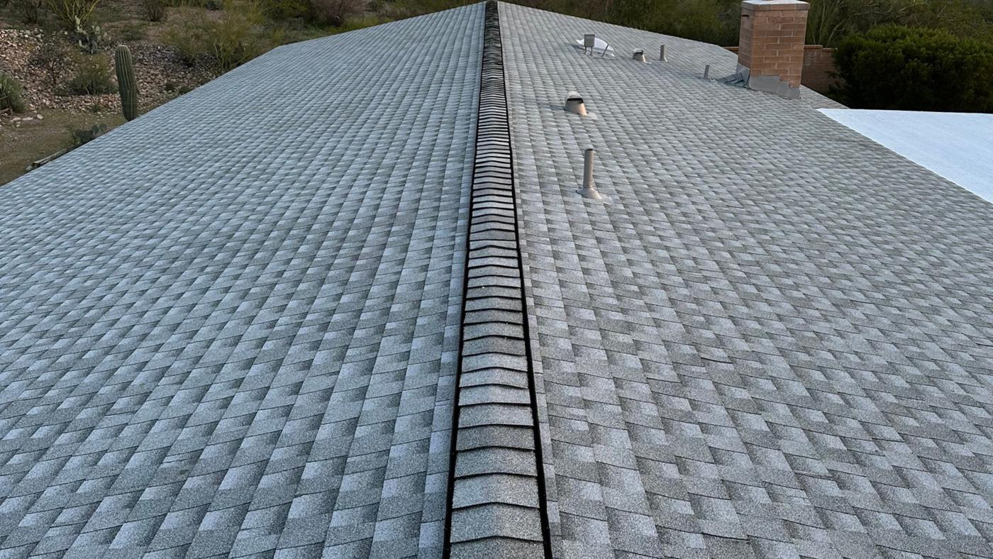 GAF Cobra ridge vent beneath ridge caps on a Pewter Gray shingle roof.