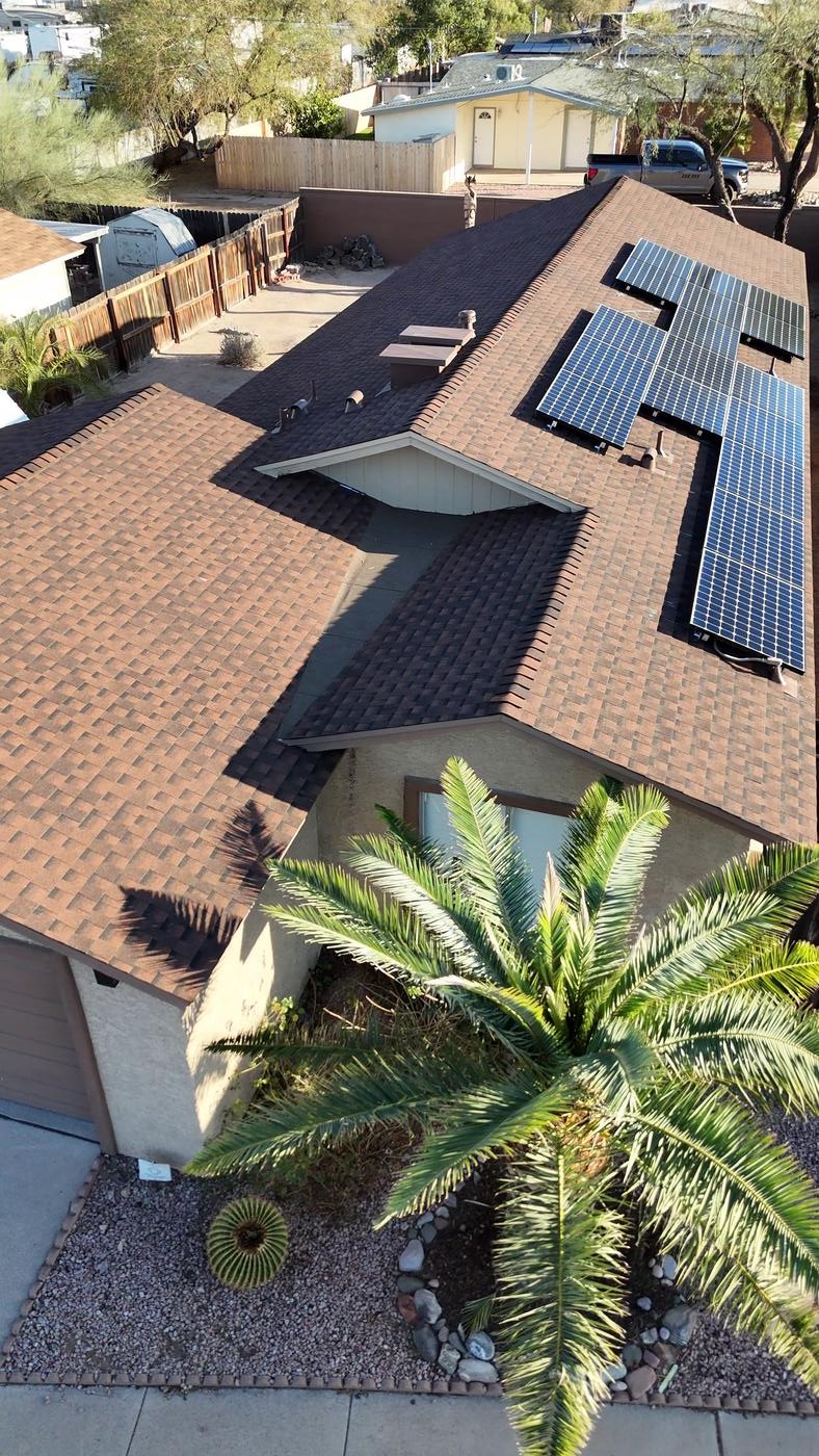 Angled aerial view of a finished Barkwood shingle roof with solar panels reinstalled.