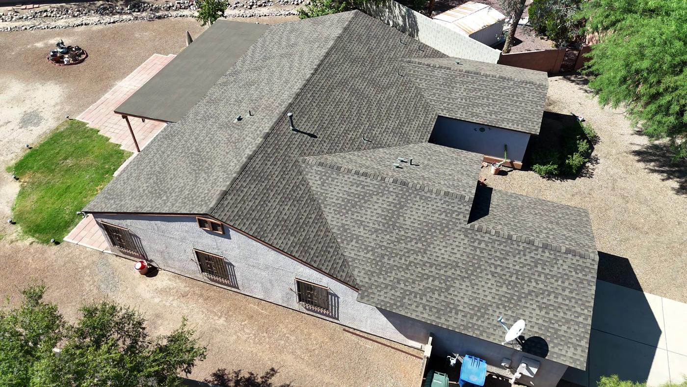 Aerial view of a finished shingle roof with an adjoining modified bitumen flat roof.