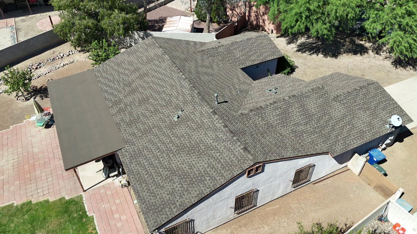 Aerial view of a finished shingle roof and modified bitumen flat roof section.