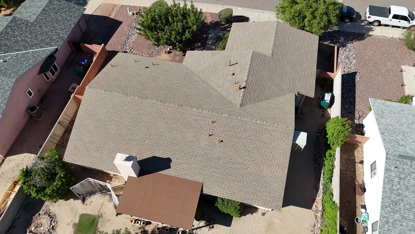 Aerial view of a finished shingle roof with a modified bitumen flat roof section.