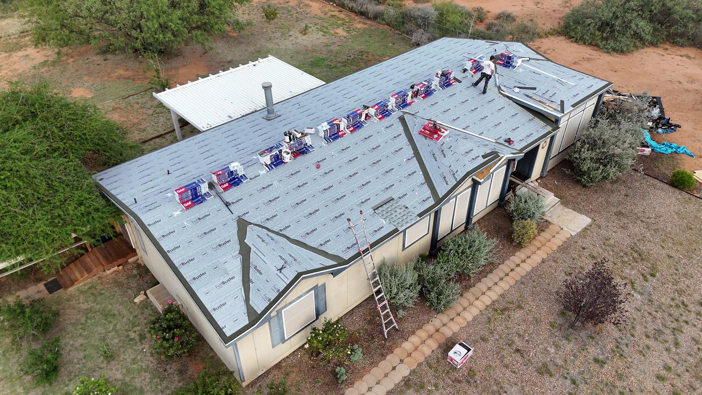 Shingle roof installation in progress with GAF FeltBuster synthetic underlayment exposed.