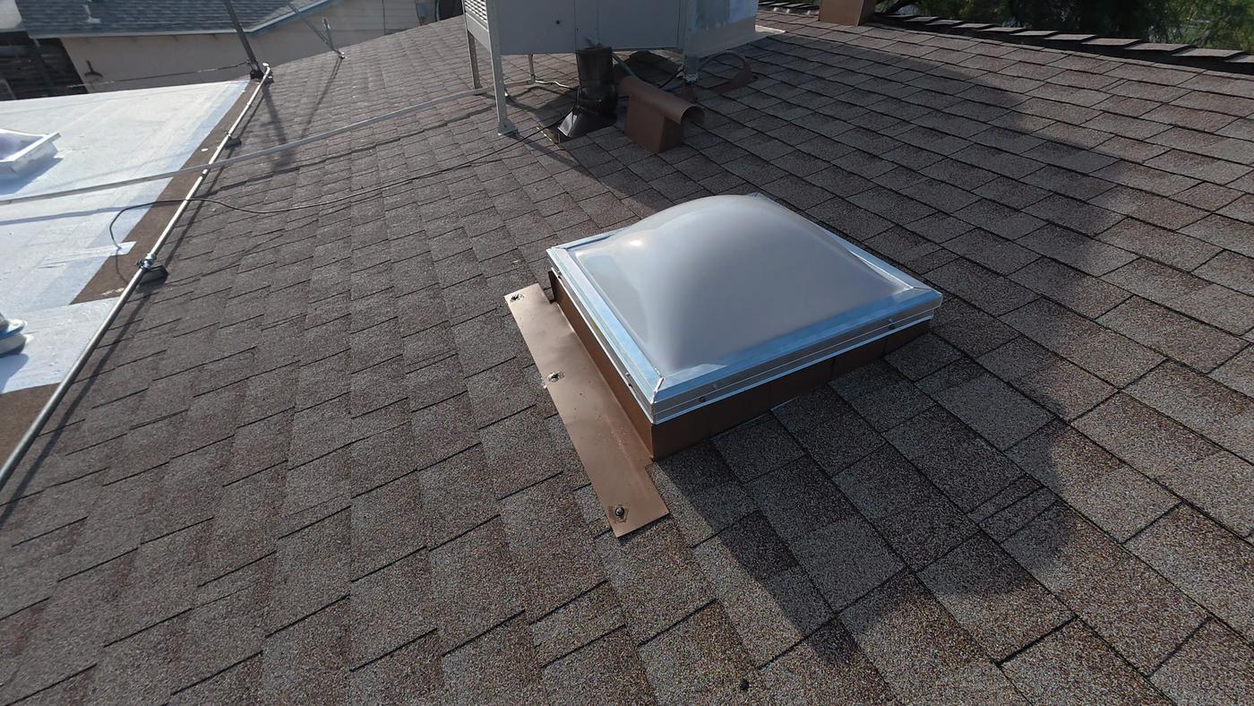 Skylight flashing detail on a finished asphalt shingle roof.