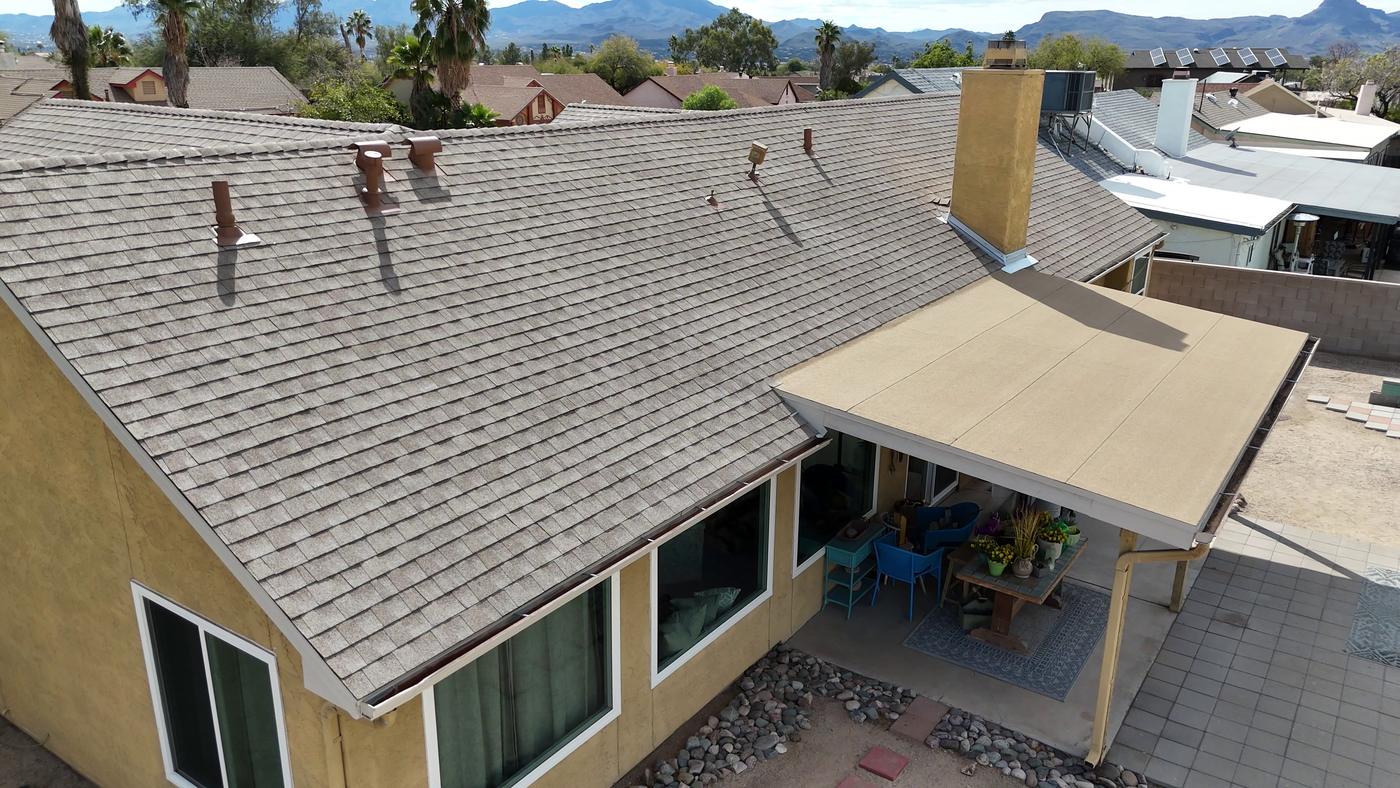 Finished shingle roof adjoining a low-slope modified bitumen roof.