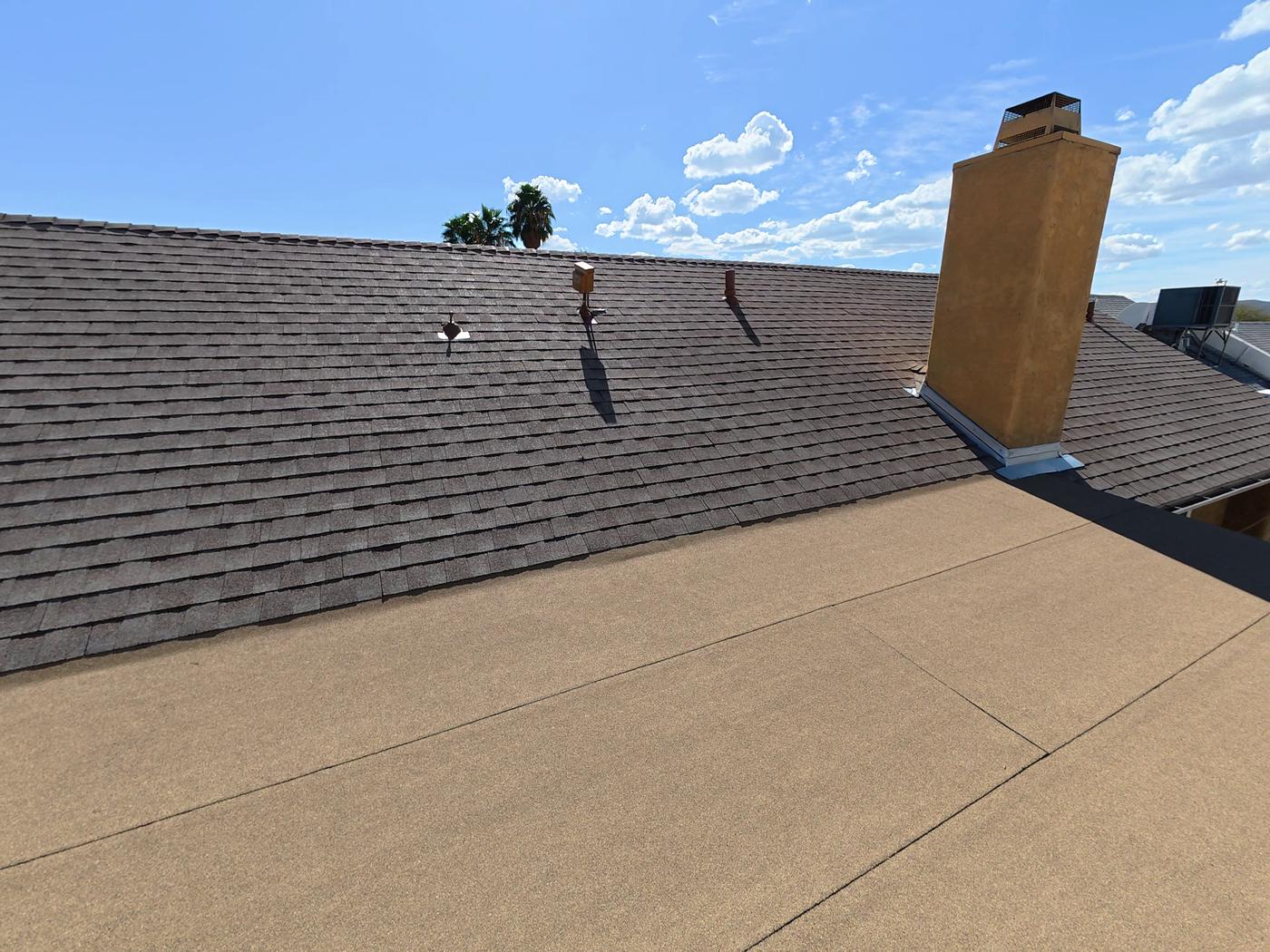 Finished shingle roof with a low-slope modified bitumen transition and chimney flashing.