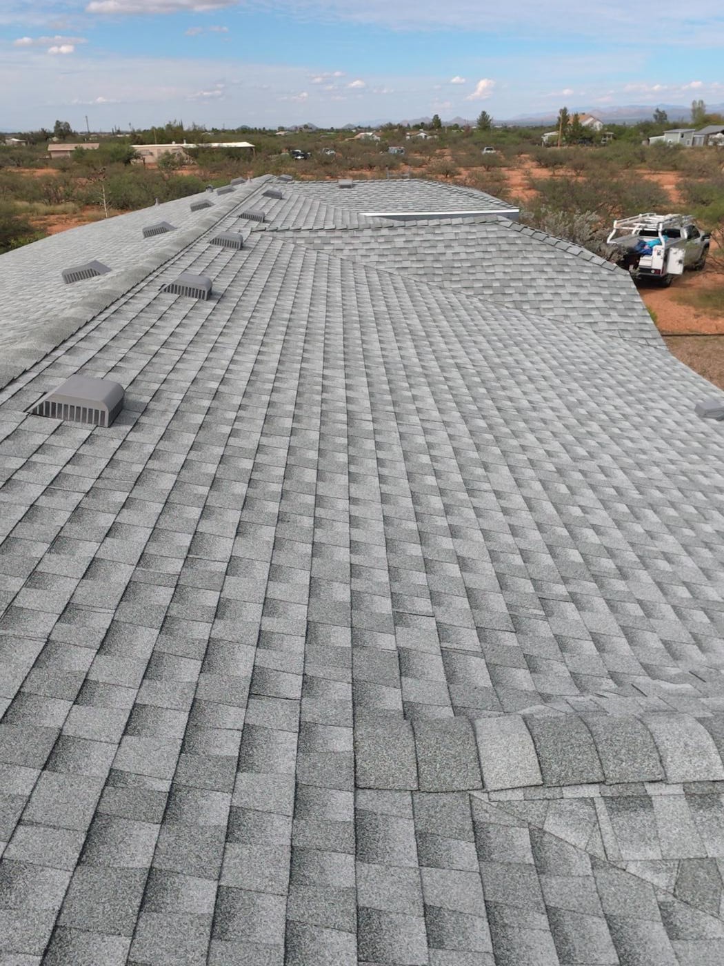 Finished asphalt shingle roof viewed along the roof slope.