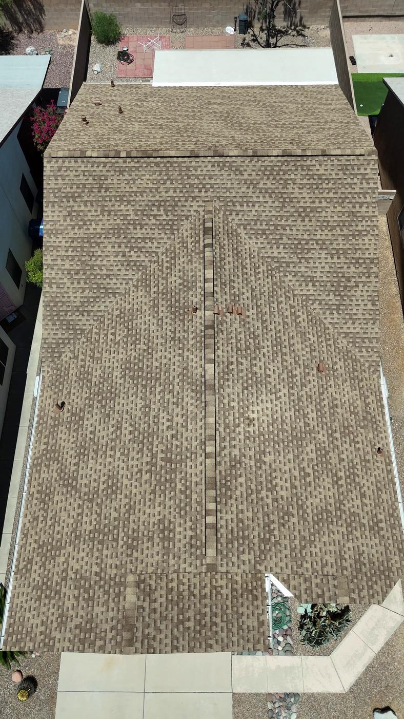 Overhead view of a finished asphalt shingle roof.