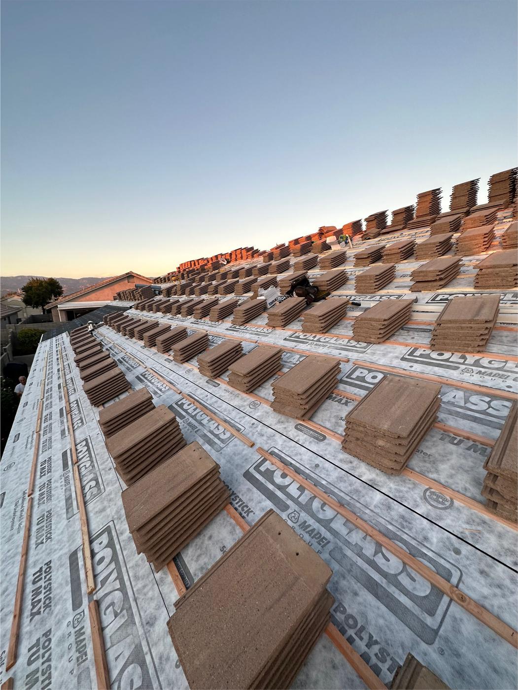 Flat-profile tile roof installation in progress.