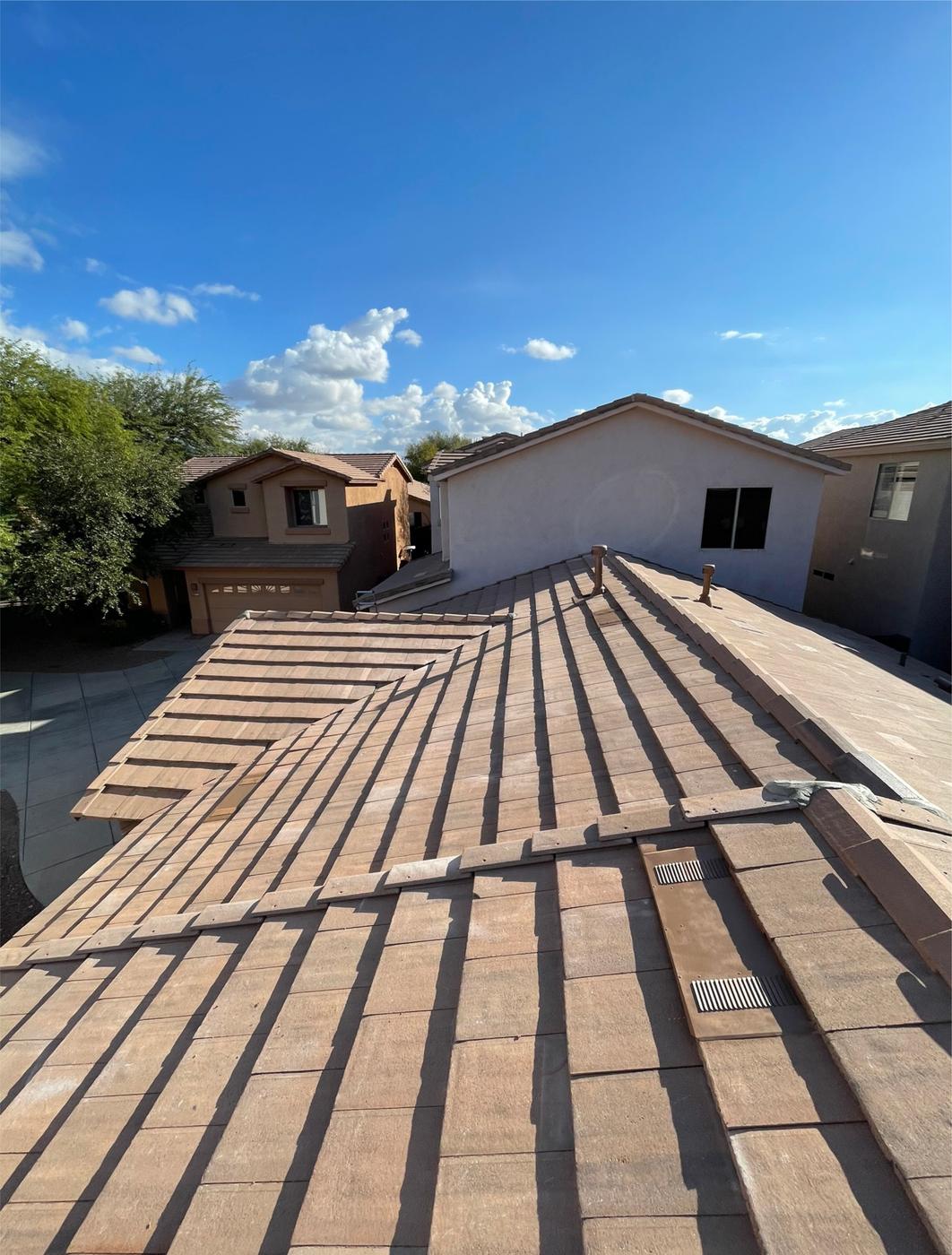 Finished concrete tile roof with roof vent flashing.