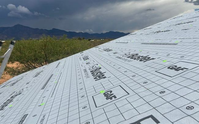 Storm clouds gathering over a Tucson roof with synthetic underlayment installed, ready for monsoon season