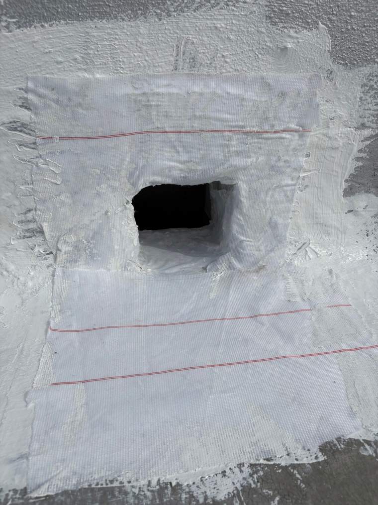 Reinforcing fabric embedded around the scupper opening during the repair