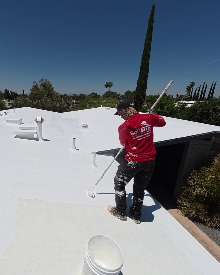 SolTerra crew member rolling acrylic coating onto a Tucson flat roof