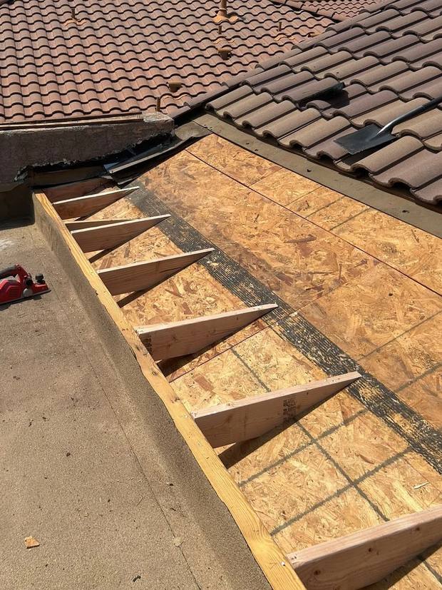 Tapered framing built over new decking where the tile roof meets the flat roof
