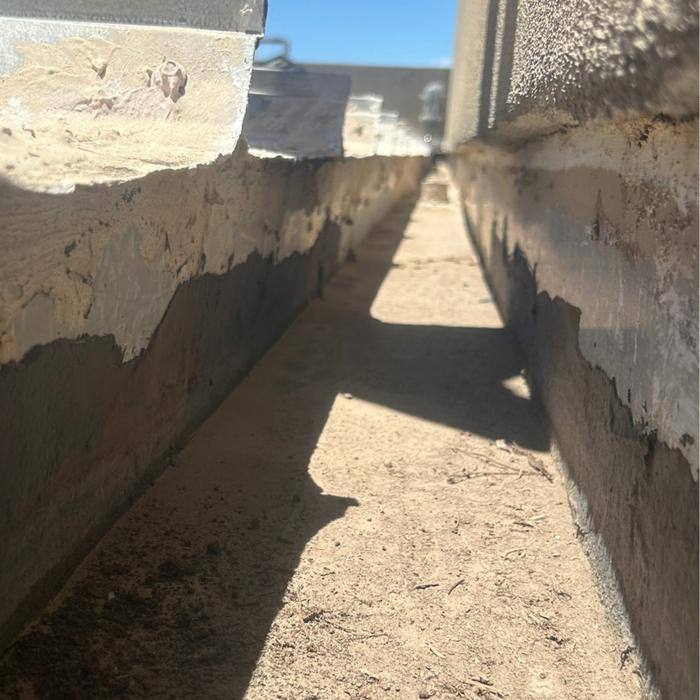 Deteriorated drainage channel between parapet walls on a Tucson flat roof