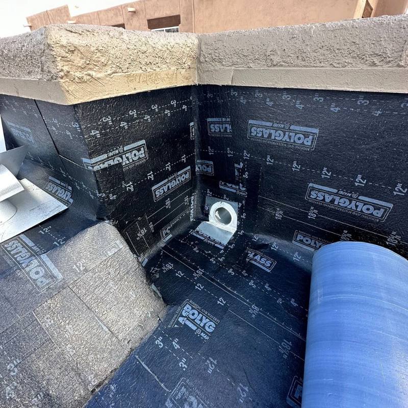 A new scupper outlet set into fresh Polyglass membrane at a parapet corner