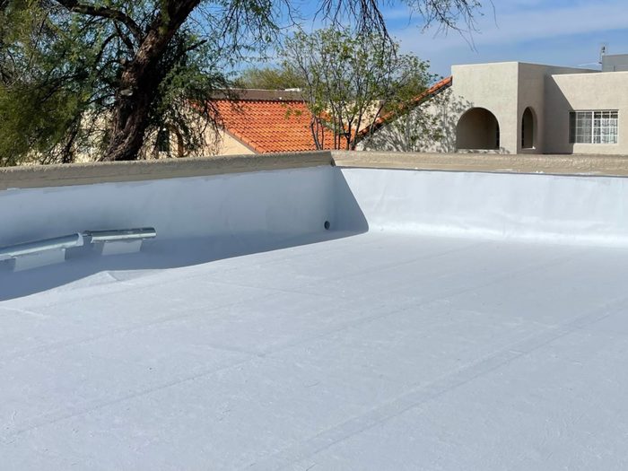 Flat roof drain and scupper managing water drainage