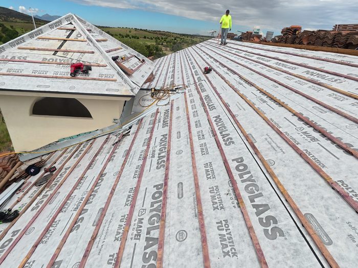 Waterproofing underlayment being installed on a roof deck